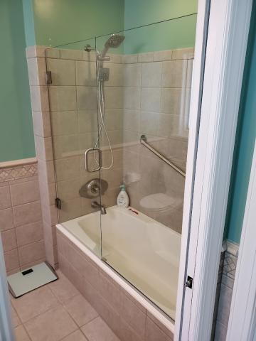 A skillful install of a glass shower door on a tub